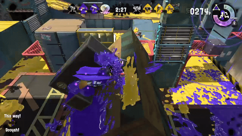 A girl with octopus arms for hair in a white T-shirt sprays purple ink on a moving bit of drawbridge as it goes vertical. She turns into an octopus and swims up the surface, then leaps down to ambush a fleeing yellow opponent. Finally, she doubles back, and inks some more wall to create an escape route.